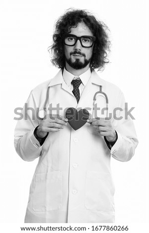 Studio shot of handsome man doctor holding red heart with both hands