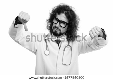 Studio shot of disappointed man doctor giving thumbs down