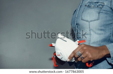 Selective focus on a black woman's hand holding a FFP3 mask.  Coronavirus protection.  Copy space.