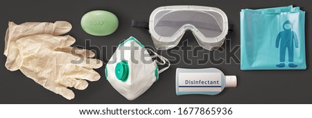 Corona Virus Covid-19 protection equipment consisting of protection mask, goggles, disposable gloves and suit, disinfectant and soap Royalty-Free Stock Photo #1677865936