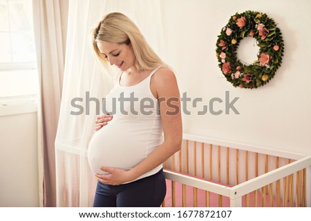 A pregnant woman on the bed at home