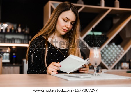 A woman is reading a book in a restaurant
