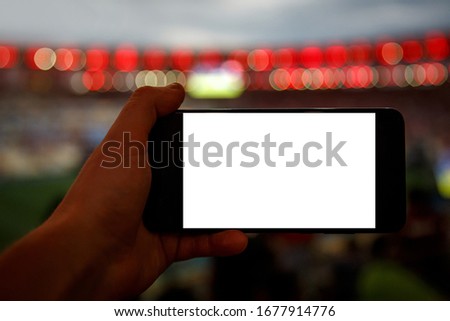 Using smartphone on football stadium. Black screen