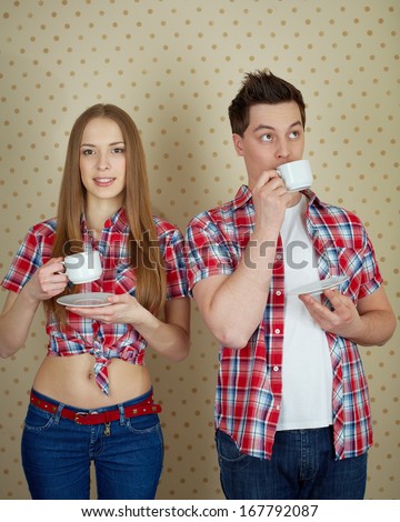 Portrait of young couple drinking tea in isolation