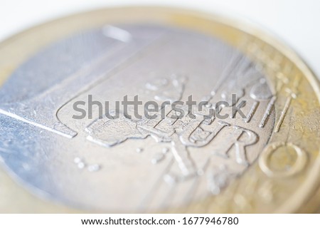 One euro coin, macro photo. The concept of the exchange rate, finance, savings, cash and coins. Used coin.