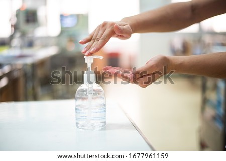 Nurse hands using wash hand sanitizer gel pump dispenser before 
nursing care a patient in hospital ward,Disinfection concept. Royalty-Free Stock Photo #1677961159