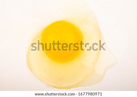 A broken chicken egg without a shell on a white background. Close up.