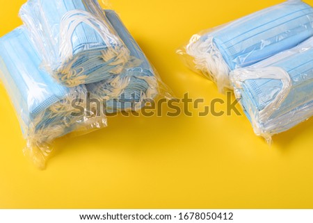 packs of medical face masks on a yellow background