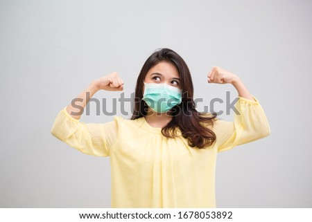 Portrait of a cheerful and healthy young woman asian wearing medical mask. Pandemic 2019 Coronavirus 2019-nCoV Concept. Royalty-Free Stock Photo #1678053892