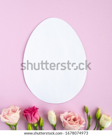Easter creative composition.  Flat lay with shape of easter egg, frame of flowers on pink  background. Minimal spring concept. Copy space 