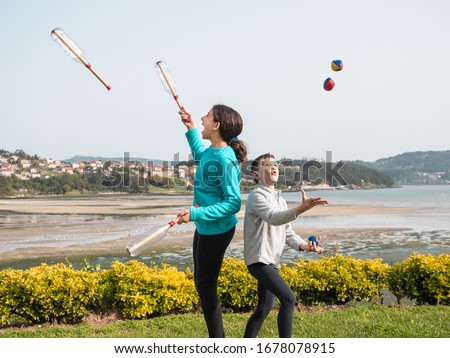 young boy and girl playing in the garden, juggling with balls and home made juggling clubs, sports and active lifestyle concept Royalty-Free Stock Photo #1678078915