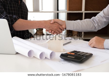Engineer and partner are shaking hand after finishing discuss about construction plan at the office, Engineering concept. Royalty-Free Stock Photo #1678081183