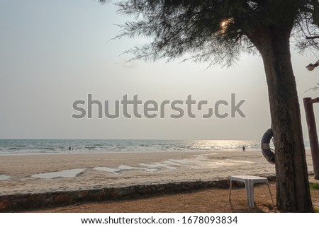 Picture of a beach with white sand, quiet and peaceful evening. The setting sun and clouds in Thailand