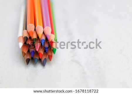 assortment of color pencils on a light distressed background