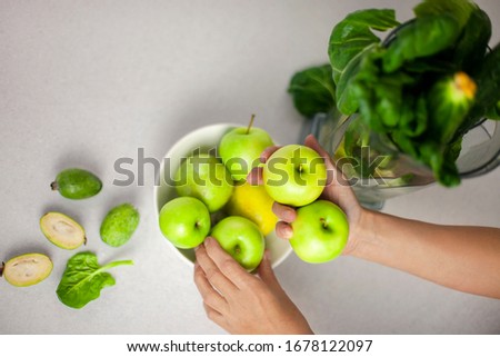  cook prepared a set of products on the kitchen table for making a healthy green smoothie: apple, spinach, lemon. Morning detox for a healthy lifestyle, ketone diet, raw food diet