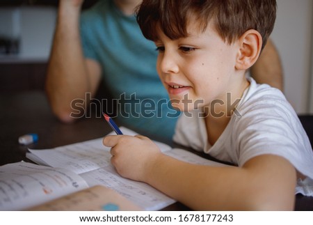 Schoolboy doing homework with his Dad