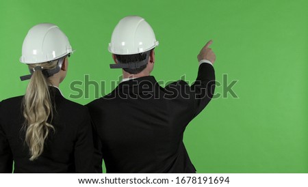 Rear View of Male Engineer Pointing Up with Female Engineer, Chroma Key