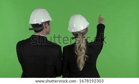 Rear View of Male and Female Construction Engineers Pointing up, Chroma Key