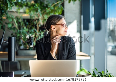 Young caucasian woman working on her laptop at restaurant.