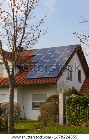 rooftop with solar panels and yellow flowers at south germany springtime sunny day Royalty-Free Stock Photo #1678224355