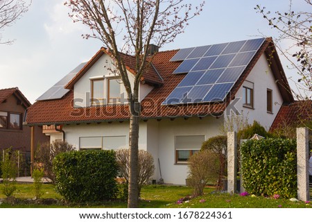 rooftop with solar panels and yellow flowers at south germany springtime sunny day Royalty-Free Stock Photo #1678224361