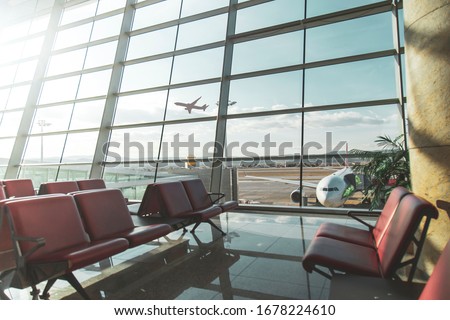 An empty terminal, aircrafts are waiting and preparing for their next flight and one of them taken off Royalty-Free Stock Photo #1678224610