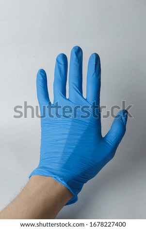 hand in a medical glove, gestures. Suitable for demonstrating something on the topic of medicine or chemistry