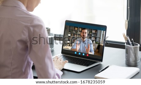 During corona virus or covid19 pandemic outbreak all negotiations performing via videoconferencing application, process of job interview distantly, view over female shoulder applicant at laptop screen Royalty-Free Stock Photo #1678235059
