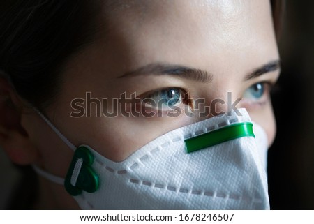 portrait of a girl in a protective mask against coronavirus. virus protection mask. Covid 2019. Covid 2020. young woman look. Close-up eyes.