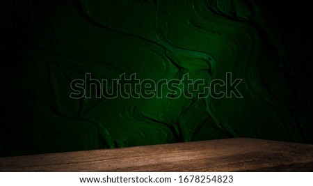 Empty, free, wooden table in front of an abstract dark wall background. Can be used to display or edit your products.