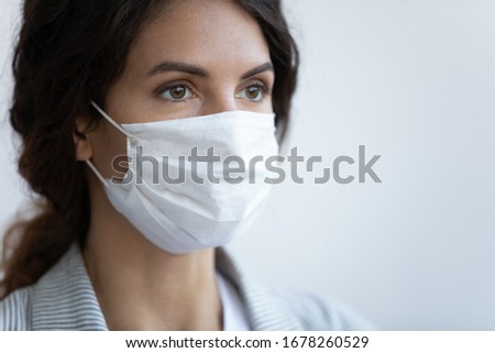 Close up image woman in facial medical mask on blue background, concept of protection to globally spread pandemic infection disease coronavirus or COVID-19 illness that affect your lungs and airways Royalty-Free Stock Photo #1678260529