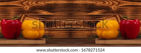 Bell peppers and rosemary on a wooden background. Duplicate image, vegetarian food and diet nutrition concept