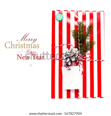 Christmas gift box and decorations isolated on white background. Vintage gift box with red paper package and blank gift tag  (with easy removable sample text)