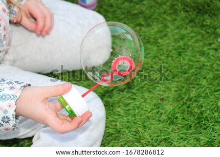 lovely little girl blowing soap bubbles.