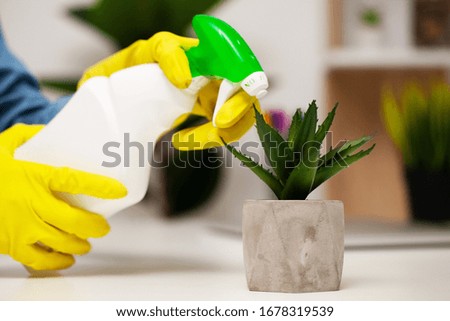 Close up of worker hand wiping dust in office in yellow gloves