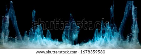 Blue ink in water on a black background .  Royalty-Free Stock Photo #1678359580