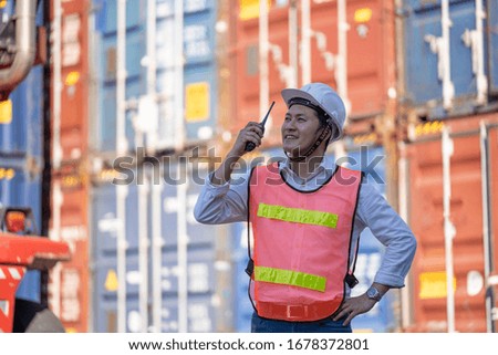 Logistics engineer control at the port, loading containers for trucks  export and importing logistic concept