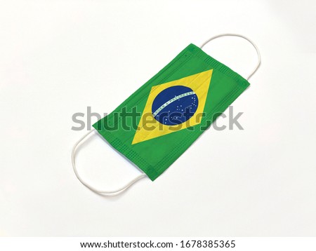 Concept. Conceptual: Disposable medical surgical face mask with Brazil country flag superimposed on it, on white background. Protection against Covid-19 coronavirus outbreak.
