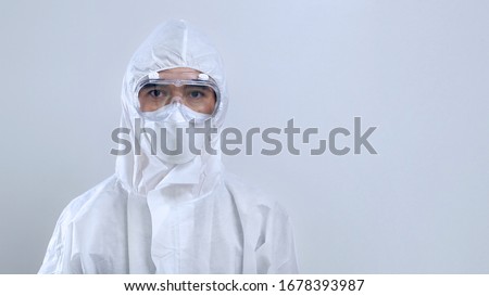 Portrait confident Asian doctor in protective PPE suit wearing face mask and eyeglasses Royalty-Free Stock Photo #1678393987