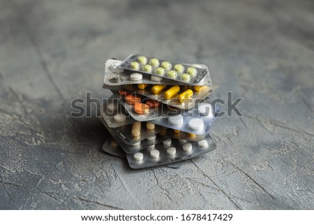 medicines in tablets and capsules on a gray background