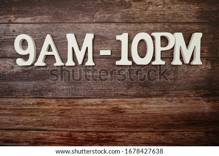Opening Times 9 am to 10 pm letter on wooden background