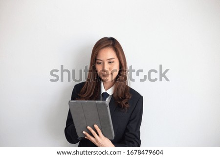 An Asian woman is happily standing in print in the tablet