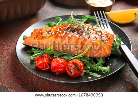 Plate with cooked salmon fillet on color background Royalty-Free Stock Photo #1678490950