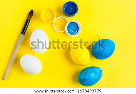 series for a master class on egg painting. Easter master class. Step 2. white and multicolored eggs on a yellow background with blue and yellow paint