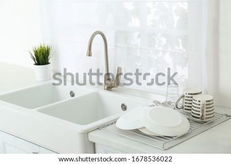 Clean dishes drying on rack in modern kitchen Royalty-Free Stock Photo #1678536022