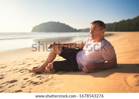       adult man enjoys sunset by the sea                         