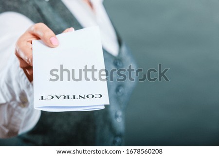 Business documents legal concept - closeup serious businesswoman holding contract in hand