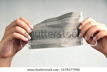 masker in hand with grey background Royalty-Free Stock Photo #1678577986