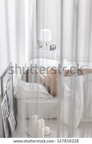Woman sleeping in a white bed. Relaxing at home.