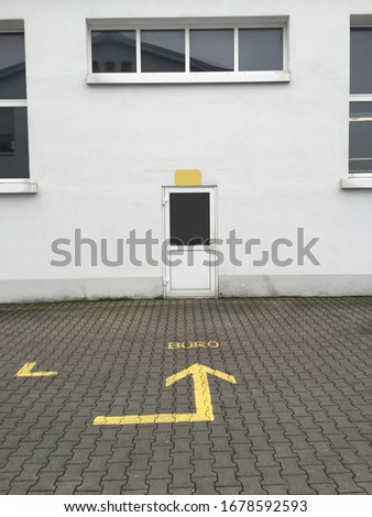 A vertical shot of an arrow leading to the door of the building